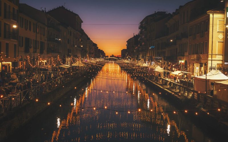 reflective photography of string lights above river
